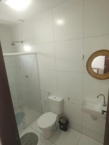 ein weißes Badezimmer mit Toilette und Waschbecken in der Unterkunft casa temporada praia de sonho verde, Paripueira - Alagoas in Paripueira