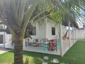 einen Tisch und Stühle neben einer Palme in der Unterkunft casa temporada praia de sonho verde, Paripueira - Alagoas in Paripueira