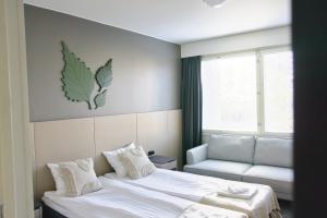 萨翁林纳Hotelli Savonlinna的一间带床、沙发和窗户的卧室