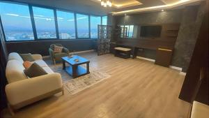 een woonkamer met banken en een tv in een gebouw bij İdil Haznedar Otel in İdil