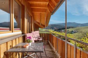 Un balcón con mesa y sillas y una vista en Stockerhof, en Elzach