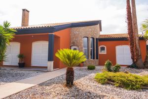 a house with palm trees in front of it at Verde Verdilhão Villa 
