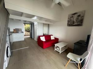 een woonkamer met een rode bank en een tafel bij Colombus Résidence in Oyster Pond