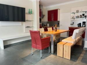 a kitchen with a wooden table and red chairs at Lounge 04 in Norderney +10 photos