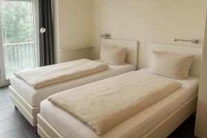 two beds sitting next to each other in a room at Lounge 04 in Norderney