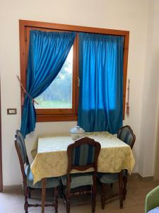 Una habitación con una mesa y sillas y una ventana. en Agriturismo Cavendo Tutus, en Roma