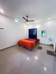 une chambre avec un lit et un ventilateur de plafond dans l'établissement The Secret Sector, à Gokarna