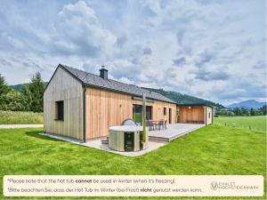 a wooden house with a deck in a field at Chalet Hochsteiermark in Mariazell