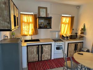 eine Küche mit weißen Geräten und einem Tisch mit Stühlen in der Unterkunft Apartment in Montagne Charlot with stunning view of the lagoon in Saint Gabriel + 3 Fotos