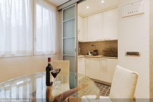 a glass table in a kitchen with a bottle of wine at Brera Apartments in Duomo in Milan +31 photos