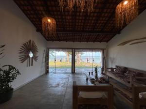 a living room with a table and chairs and windows at Pousada Vila de Água Boa in Salvaterra