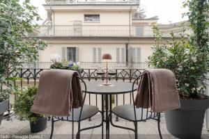 a patio with two chairs and a table in front of a building at Brera Apartments in Duomo in Milan