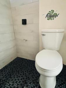 a bathroom with a white toilet in a shower at Hotel Tropical in Villahermosa