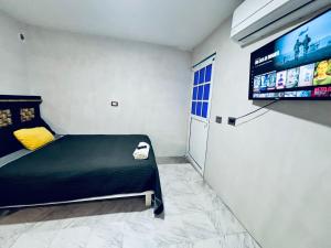 a bedroom with a bed and a tv on the wall at Hotel Tropical in Villahermosa