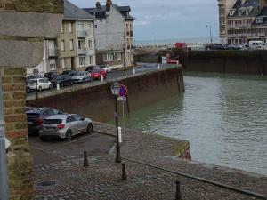 een auto geparkeerd op een parkeerplaats naast een rivier bij Marc 3 in Saint-Valéry-en-Caux