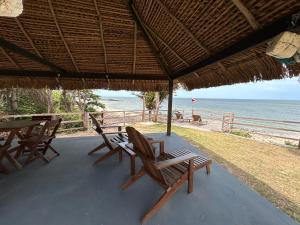 a porch with chairs and a table and the beach at Pousada Vila de Água Boa in Salvaterra