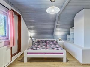 a bedroom with a bed with a purple comforter at Holiday Home Leisure Lounge & Pool by Interhome in Kvasiny