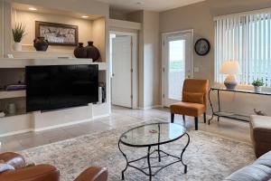 ein Wohnzimmer mit Fernseher und Tisch in der Unterkunft Sunsets & Smiles in Oro Valley