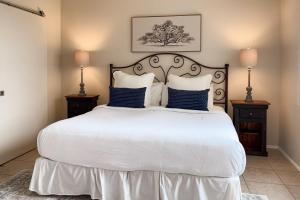 ein Schlafzimmer mit einem großen weißen Bett mit blauen Kissen in der Unterkunft Sunsets & Smiles in Oro Valley + 28 Fotos