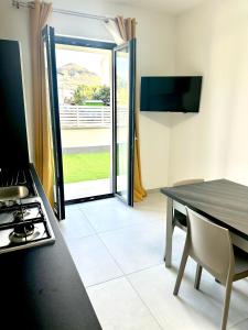 een keuken met een tafel, een fornuis en een raam bij Levante Casa Vacanze in Torrenova