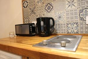 a kitchen counter with a stove and a microwave at Chambre d'Aut' in Autun