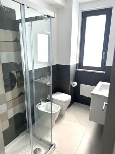 a bathroom with a toilet and a glass shower at Levante Apartments in Torrenova +22 photos