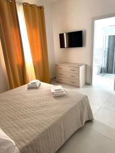 a bedroom with a bed with two towels on it at Levante Apartments in Torrenova