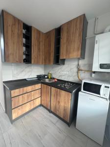a kitchen with wooden cabinets and a white refrigerator at YarNika in Berehove