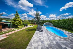 a swimming pool in a backyard with a glass house at Chalupa Pod Starú horú in Bohuslavice
