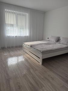 a white bedroom with a bed and a window at YarNika in Berehove