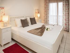 a bedroom with a large white bed with flowers on it at Apartment Réze 5 by Interhome in Ovronnaz