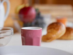 a pink cup sitting on a table with doughnuts at Apartment Réze 5 by Interhome in Ovronnaz