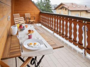 a table with a plate of eggs on a balcony at Apartment Réze 5 by Interhome in Ovronnaz