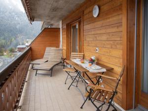 a balcony with chairs and a table on a roof at Apartment Réze 5 by Interhome in Ovronnaz