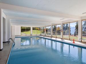 an indoor swimming pool with blue water and windows at Apartment Cransalpin Apt- 3 - Secteur 1 by Interhome in Vermala