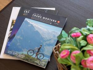 two magazines on a table next to a basket of flowers at Apartment Cransalpin Apt- 11 - Secteur 1 by Interhome in Vermala +46 photos