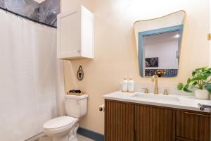 Un baño con inodoro, lavabo y espejo. en The Francesca - Apt 333, en Bryan 23 fotos más
