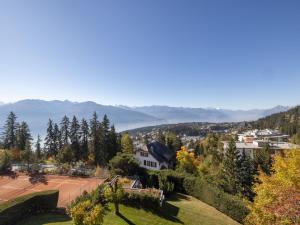 a park with a tennis court and mountains in the background at Apartment Cransalpin Apt- 11 - Secteur 1 by Interhome in Vermala
