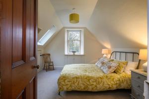 a bedroom with a bed with a yellow blanket at The Stable Flat - 20 minutes from St Andrews in Cupar