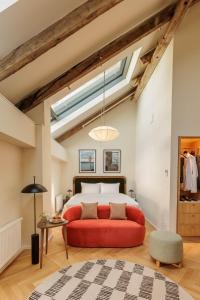 a bedroom with a red bed and a skylight at Wilde Vienna Fleischmarkt in Vienna
