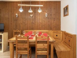 a dining room table with chairs and a wooden wall at Apartment Galaxie 218 by Interhome in Verbier +17 photos
