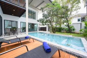 une piscine dans l'arrière-cour d'une maison dans l'établissement New Luxury Pool Villa Bangtao Free Electricity & Daily Cleaning, à Ban Pak Lak