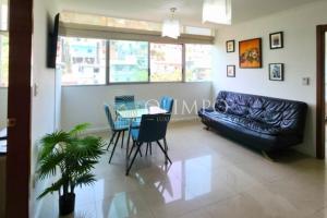 a living room with a black leather couch and a table at EcuOlimpo Lighthouse Stay double in Guayaquil