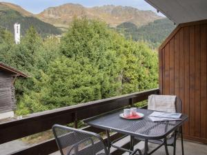 a table and chairs on a balcony with mountains at Apartment Galaxie 218 by Interhome in Verbier