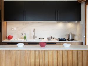 uma cozinha com armários pretos e bancadas brancas em Apartment Val Neige 11 by Interhome em Verbier