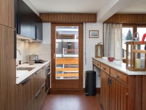 uma cozinha com armários de madeira e uma porta de correr em Apartment Val Neige 11 by Interhome em Verbier