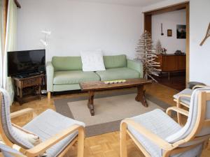 a living room with a green couch and a christmas tree at Apartment Val Neige 11 by Interhome in Verbier