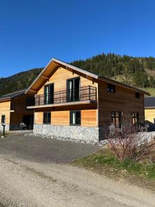 a wooden house with a balcony on the side of it at Chalet am See! in Afritz