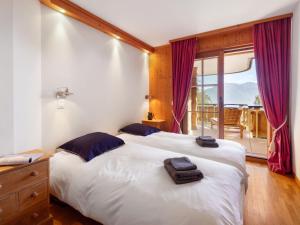 a bedroom with a large white bed and a window at Apartment Résidence Le Chalet 5 by Interhome in Crans-Montana