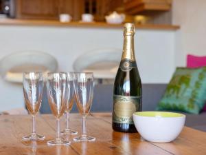 a bottle of champagne and four wine glasses on a table at Apartment Résidence Le Chalet 5 by Interhome in Crans-Montana +38 photos